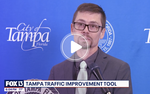 City of Tampa official speaking at press conference with blue background